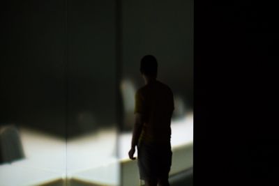 Rear view of silhouette man walking in corridor