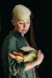 Creative portrait of vegan woman holding vegetables. veganism, vegetarianism, plant-based diet