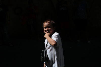 Portrait of young woman standing against wall