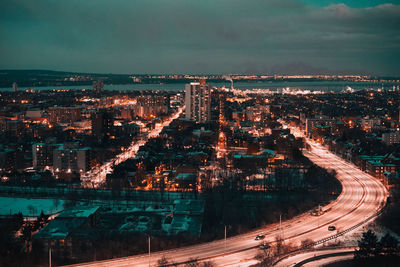 High angle view of illuminated city against sky at dusk