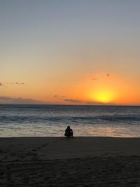 Silhouette person on beach against sky during sunset