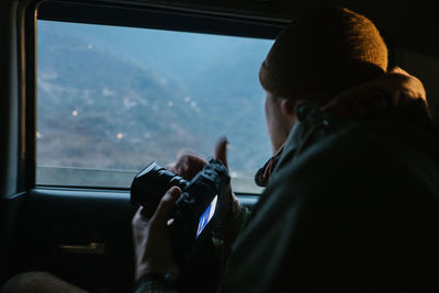 Man photographing while sitting in car 