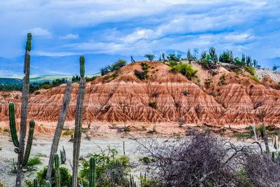 Scenic view of hill against cloudy sky