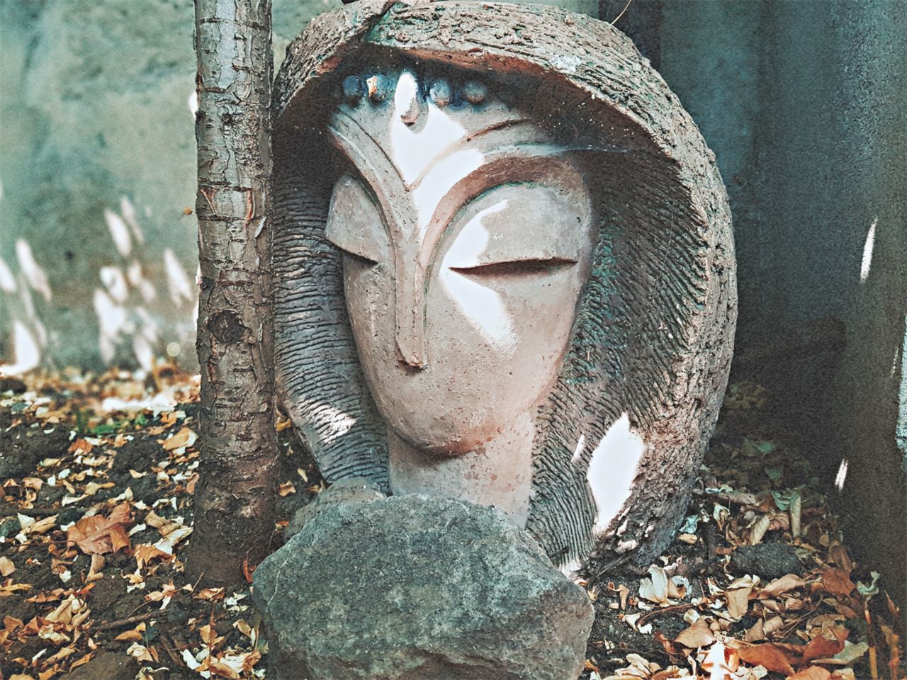 CLOSE-UP OF OLD STATUE AGAINST STONE WALL