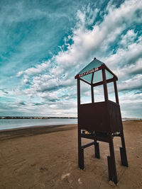 Lifeguard hut on beach against sky