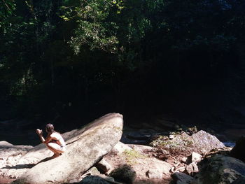 People sitting on rock in forest