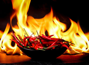 Close-up of red chili peppers against fire
