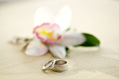 Close-up of white flower and rings on table