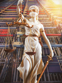 Low angle view of lady justice statue against shopping carts