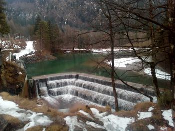 Scenic view of waterfall in forest during winter