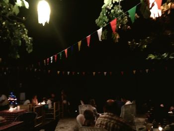 Group of people in illuminated street at night