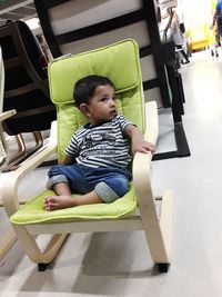 Cute girl sitting on chair at home