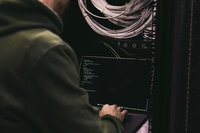 It technician working on laptop in server room