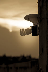 Close-up of silhouette light on beach against sky during sunset