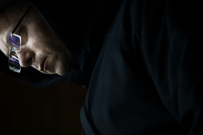 Close-up of man holding cigarette against black background