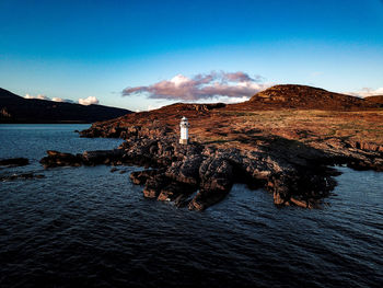 Scenic view of rocks on sea against sky