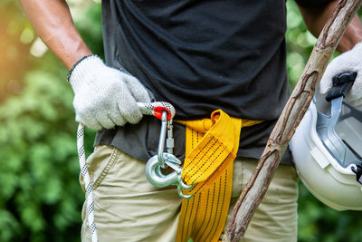 Midsection of man holding rope