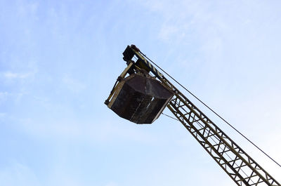 Low angle view of crane against blue sky