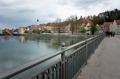 View of town by sea against cloudy sky