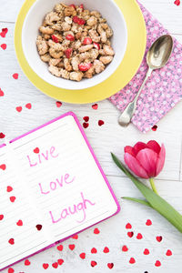 High angle view of breakfast and message with flower on table