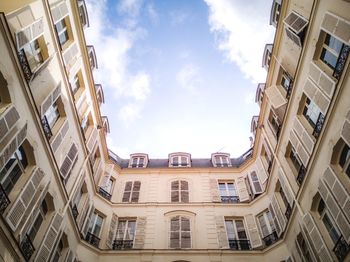 Low angle view of buildings in town against sky