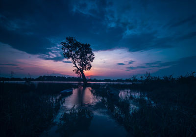 Scenic view of lake against sky at sunset