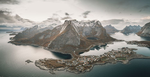 Scenic view of sea and snowcapped mountains against sky