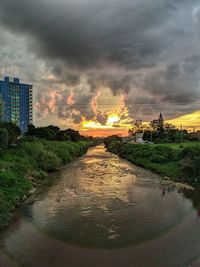 Street amidst buildings against sky during sunset