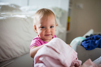 Portrait of cute baby boy lying on bed at home