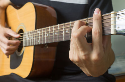 Midsection of man playing guitar