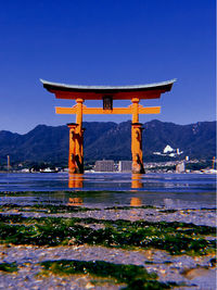 View of cross on mountain against blue sky