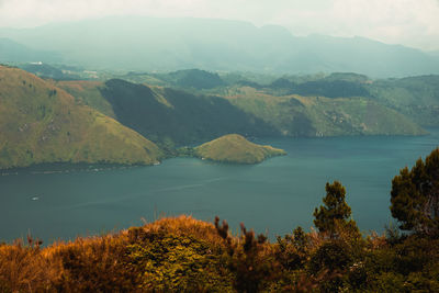 Scenic view of sea and mountains against sky