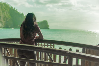 Rear view of woman looking at sea against sky