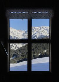 Snow covered field seen through window