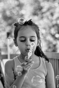 Cute girl blowing bubbles outdoors