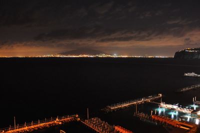 High angle view of harbor against cloudy sky at night