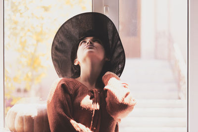 Portrait of young woman looking down at home