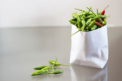 Close-up of green chili pepper in paper bag on table