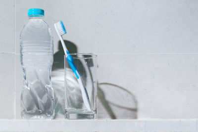 Close-up of glass bottle against white wall