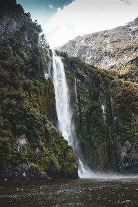 Scenic view of waterfall against sky