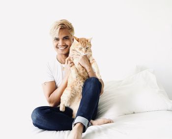 Portrait of smiling young man sitting on wall