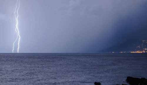 Lightning over sea against sky at night