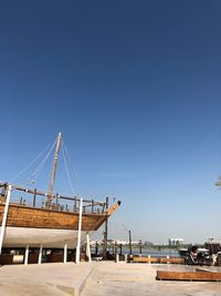 Sailboats in city against clear blue sky