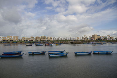 Boats moored in river against buildings in city