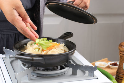 Cropped hand of man preparing food in kitchen