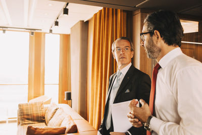 Mature financial advisors talking while walking in corridor at law office