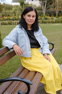 Female outdoors on the bench in the park. midaged woman looking in the camera