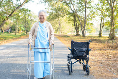 Portrait of smiling senior woman walking on road
