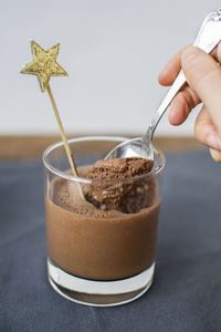 Close-up of image of person having chocolate in glass on table