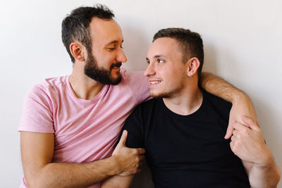 Gay couple laughing at home.